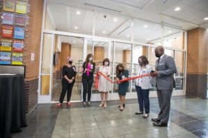Little Rock Mayor Frank Scott Jr., far right, holds the ribbon as Gloria Richard-Davis, M.D., gets ready to cut it and officially open the the new Culinary Medicine Kitchen at UAMS.