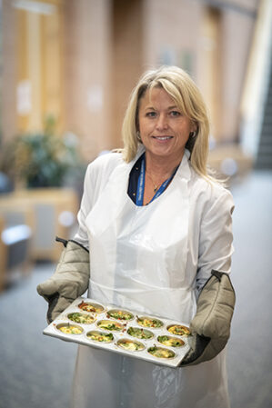 Dees Davis holding muffin tray filled with frittatas