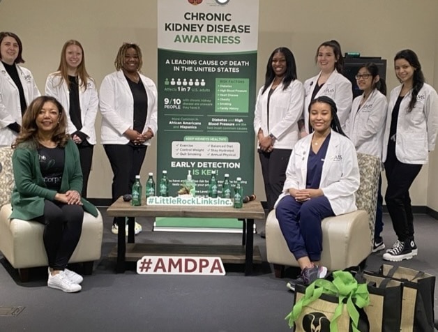 Group of students and faculty posing with Chronic Kidney Disease Awareness display