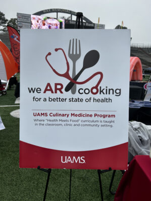 Culinary Medicine sign at the walk. The sign reads: “We AR Cooking for a better state of health. UAMS Culinary Medicine Program. Where “health meets food” curriculum is taught in the classroom, clinic, and community settings.
